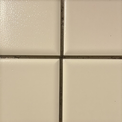 Nanocoated Grout Surface Microscopic view of grout with applied nanocoating showing water repellency and smooth surface.